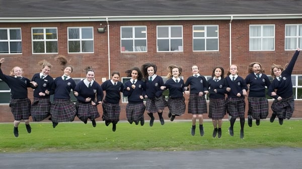 Un grupo de estudiantes de la Presentation Secondary School Kilkenny está frente a un edificio de ladrillo.