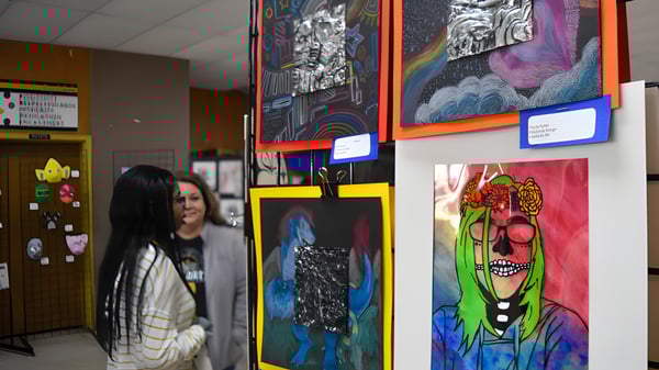 Un pasillo con coloridas obras de arte en las paredes en el campus de la Prince George Secondary School con una persona en primer plano.