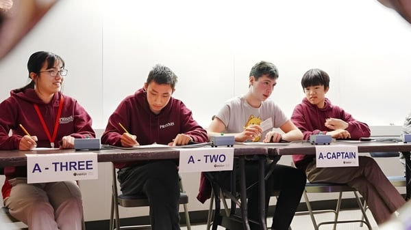 Cuatro estudiantes trabajan en escritorios en el aula de la Princeton International School of Mathematics & Science.
