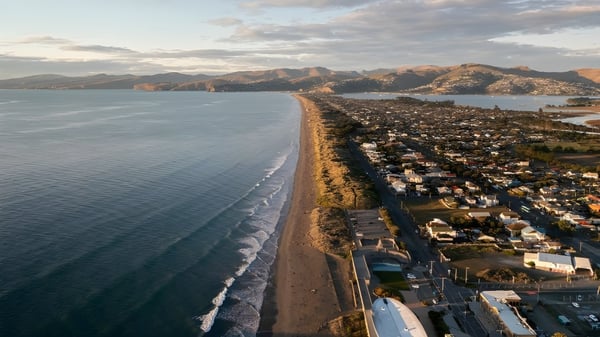 Vista del paisaje costero con playa y montañas cerca de la Pukehohe High School.
