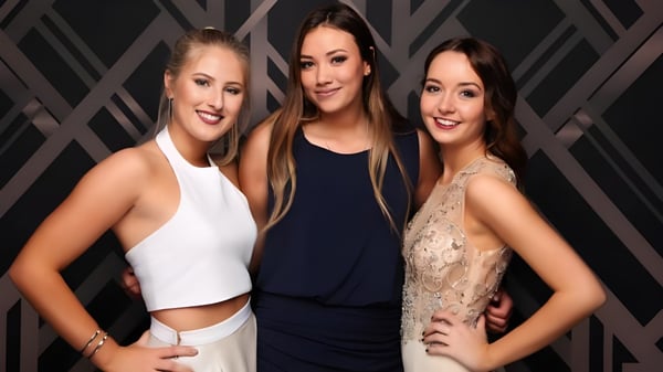 Tres estudiantes de la Pukehohe High School posan juntas frente a un fondo oscuro y geométrico.