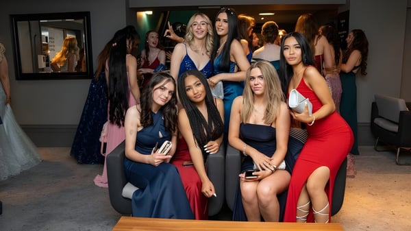 Un grupo de alumnas de la Queen Anne’s School posan en un evento formal con un espejo y arte al fondo.