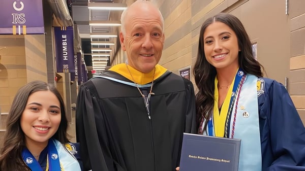 Tres personas en ropa de graduación posan para una foto en el campus de la Rancho Solano Preparatory School.