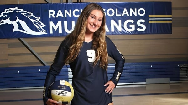 Una estudiante de la Rancho Solano Preparatory School sostiene un voleibol frente a un banner de Mustang.
