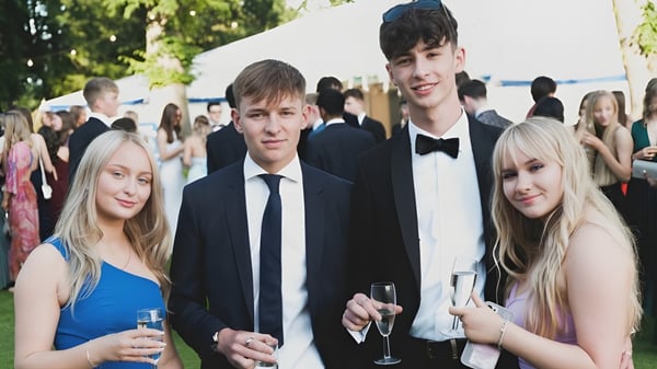 Un grupo de estudiantes del Ratcliffe College está en una recepción al aire libre con árboles de fondo.