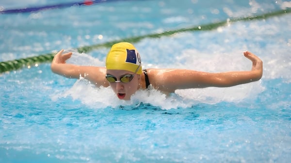 Una nadadora con un traje de baño amarillo nada con fuerza en la piscina de la Ravenswood School for Girls.