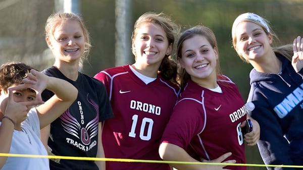 Un grupo de estudiantes en uniformes deportivos posan al aire libre en el terreno de la Regional School Unit N*26.