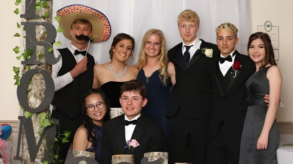 Un grupo de estudiantes de la Regional School Unit N*26 posan frente a un fondo verde para una foto grupal.