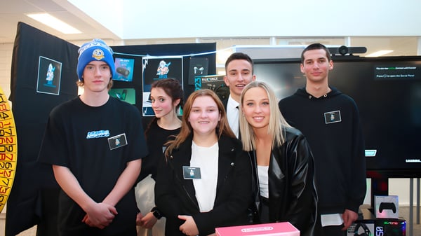 Un grupo de alumnas y alumnos de la Renmark High School están en una sala de juegos y tecnología con varias pantallas y dispositivos.