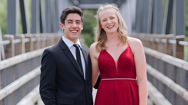 Una joven pareja sonríe en un puente en el terreno de Revelstoke Secondary School.