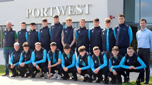 Un grupo de personas con ropa uniforme está frente al edificio del Rice College con el letrero Port West.