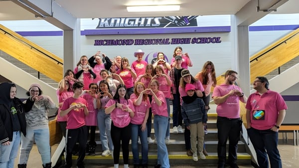 Un grupo de estudiantes se encuentra frente a una pancarta de la Richmond Regional High School.