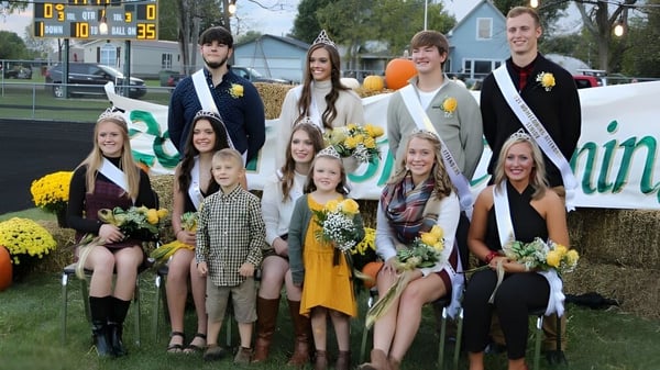 Un grupo de estudiantes de Ridgemont High School está frente a un estadio deportivo con flores en la mano.