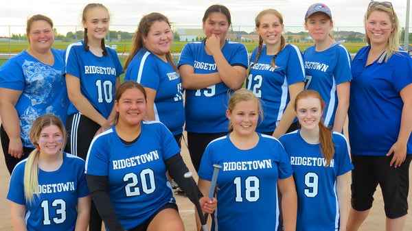 Un grupo de jóvenes deportistas está reunido en el campo de deportes de la Ridgetown District High School.