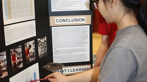 Una persona presenta un proyecto en un cartel frente a estudiantes en el Rivermont Collegiate.