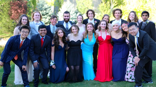 Un grupo de alumnas y alumnos de la Riverstone International School están juntos en un área verde.