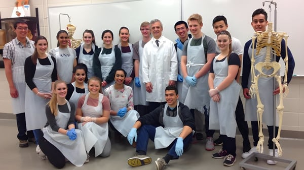Un grupo de estudiantes de la Robert Thirsk High School en el aula de formación médica con equipo médico.