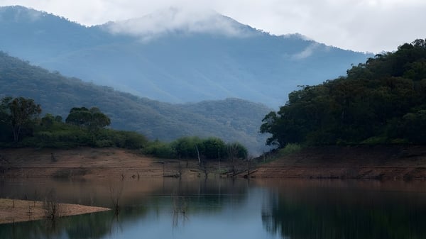 Vista de un lago tranquilo con montañas boscosas en la naturaleza cerca de la Rockingham Senior High School.