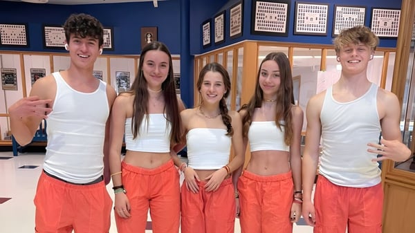 Un grupo de estudiantes de la Rockland District High School está juntos en un área con casilleros y tablones de anuncios.