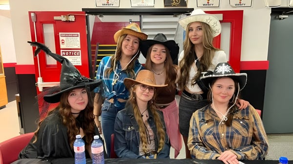 Un grupo de estudiantes de la Roncalli Central High lleva diferentes sombreros y disfraces en una sala con casilleros.