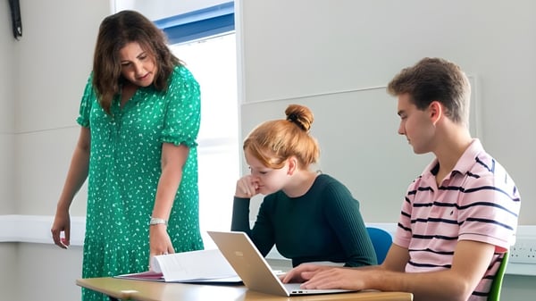Tres alumnos de la Rookwood School están sentados juntos en un aula y utilizan un portátil.