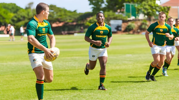 Un grupo de jugadores de rugby corre en el campo deportivo de la Rose Bay High School.
