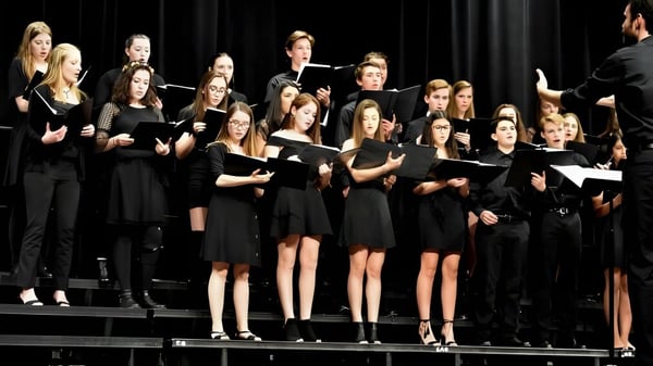 Estudiantes de la Rosemount High School cantan juntos en un escenario.