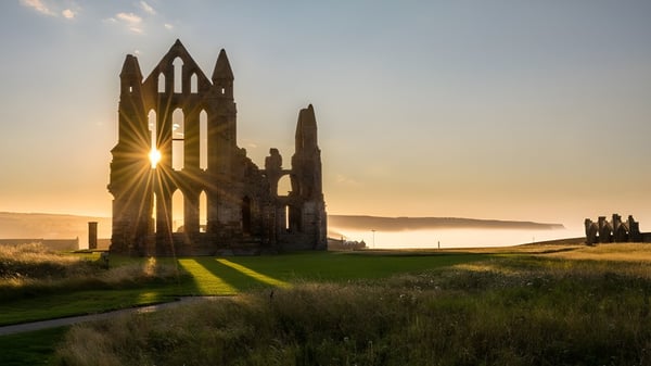 Las ruinas de una abadía se pueden ver en el terreno de la Rossall School frente a un paisaje con rayos de sol a través de las ventanas.