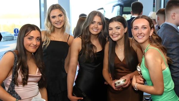 Un grupo de jóvenes alumnas de la Royal Masonic School for Girls posan juntas frente a una pared de vidrio.