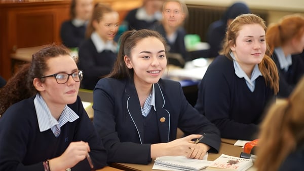 Un grupo de alumnas de la Royal Masonic School for Girls está sentada en el aula en mesas y trabajando juntas.