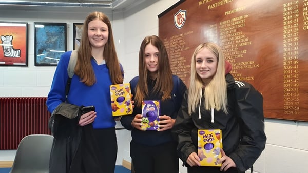 Tres alumnas están juntas en el pasillo de la Royal & Prior Comprehensive School y sostienen libros en las manos.