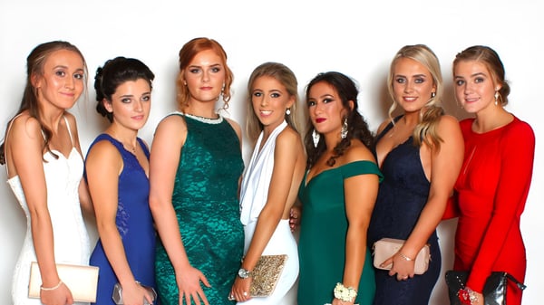 Seis estudiantes de la Royal School Dungannon posan con vestidos coloridos frente a un fondo blanco.