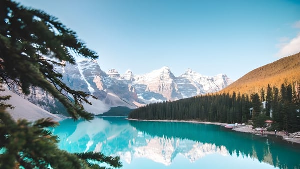 Un lago turquesa con montañas cubiertas de nieve y densos bosques cerca de Russell High School.