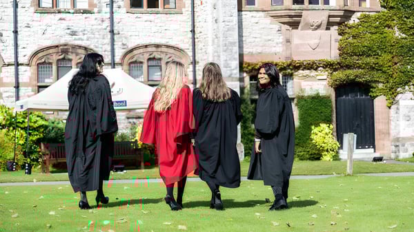 Cinco personas en togas académicas están frente a un edificio histórico en el campus de la Ruthin School.