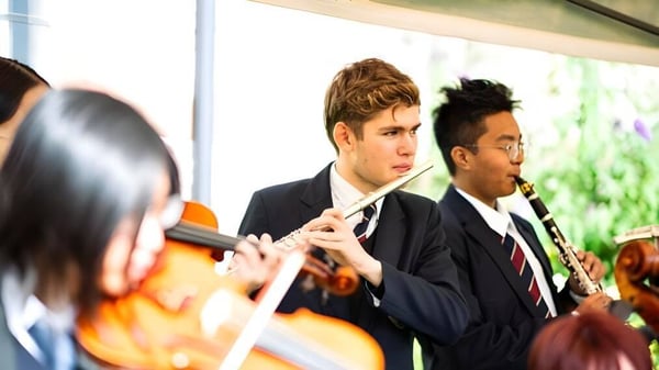 Dos estudiantes en ropa formal están en un interior en el campus de la Ruthin School.