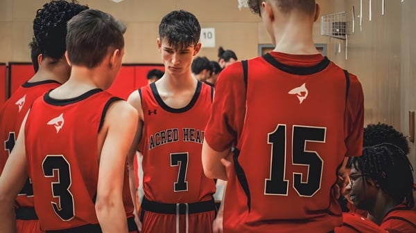 Alumnos de la Sacred Heart School of Halifax están en camisetas rojas juntos en el vestuario del equipo de baloncesto.