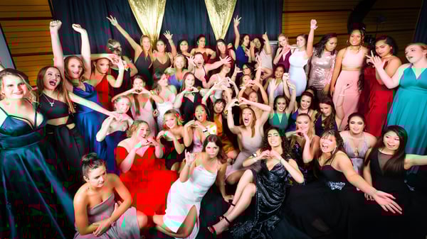 Un grupo de alumnas del Sacred Heart College Napier posando solemnemente en ropa formal con los brazos levantados.