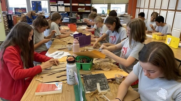 Alumnos y alumnas de la Sacred Heart Secondary School en Tullamore trabajan en proyectos de manualidades en una mesa.
