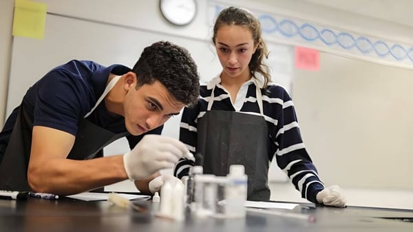Dos estudiantes de la Saint Andrews School trabajan juntos en una mesa en el laboratorio.