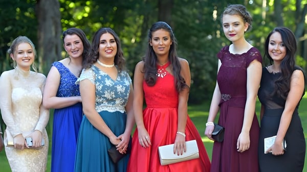 Cinco alumnas de la Salerno Secondary School están juntas en un área exterior verde vestidas elegantemente.