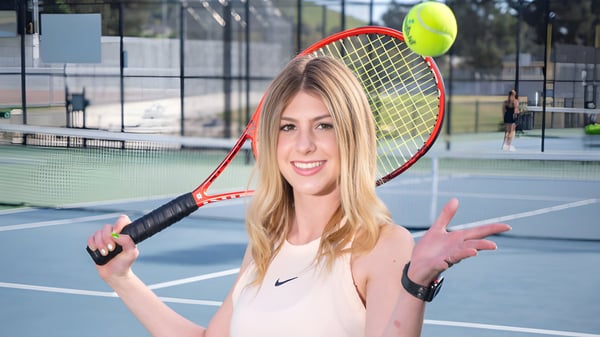Una alumna del San Luis Coastal Unified School District está con una raqueta de tenis en una cancha de tenis.