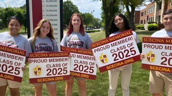 Estudiantes de la Scecina Memorial High School muestran orgullosamente sus carteles de la Class of 2025 al aire libre.