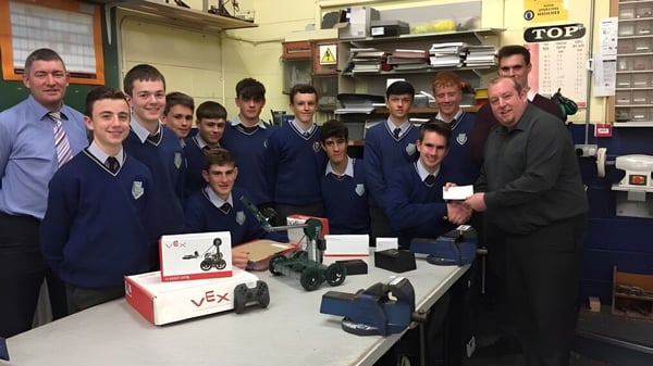 Estudiantes de la Scoil Mhuire gan Smál trabajan juntos en un proyecto de electrónica con diferentes dispositivos en un aula.