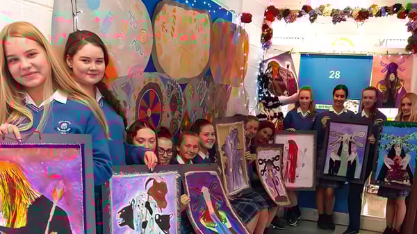 Un grupo de alumnas y alumnos están frente a un colorido mural en el aula de la Scoil Mhuire (Trim).