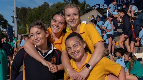 Un grupo de jóvenes mujeres está frente a una multitud en el campus de Scotch Oakburn College.