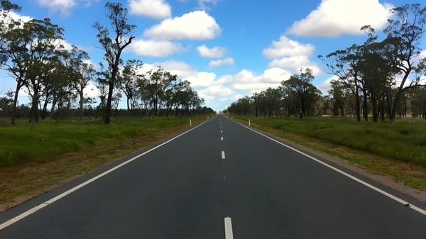 Una larga carretera recta atraviesa un paisaje verde en el terreno del Scotch Oakburn College.
