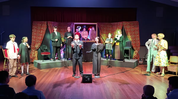 En el escenario del Scots College se pueden ver maniquíes con disfraces coloridos e inspirados en lo vintage frente a cortinas estampadas y obras de arte.