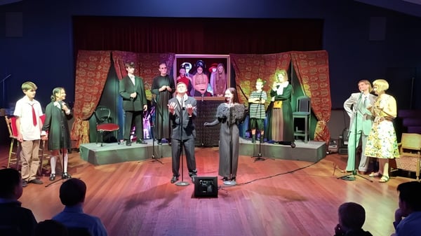 En el escenario del Scots College se pueden ver maniquíes con vestidos coloridos inspirados en lo vintage frente a una cortina estampada y obras de arte.