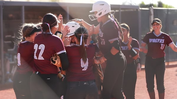 Un grupo de estudiantes del Scottsdale Unified School District está en el campo deportivo frente a un edificio escolar.