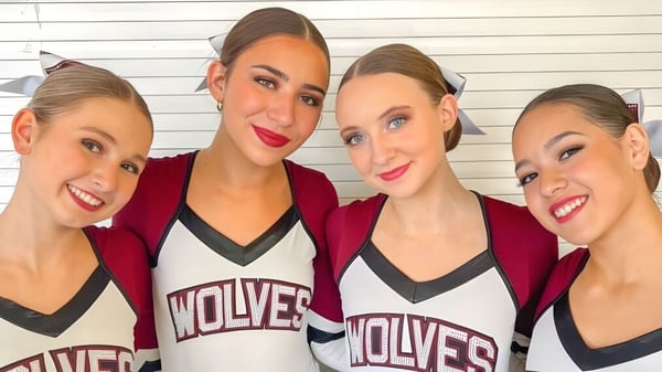 Cuatro jóvenes deportistas posan en camisetas rojas y blancas con la inscripción Wolves en el Scottsdale Unified School District.